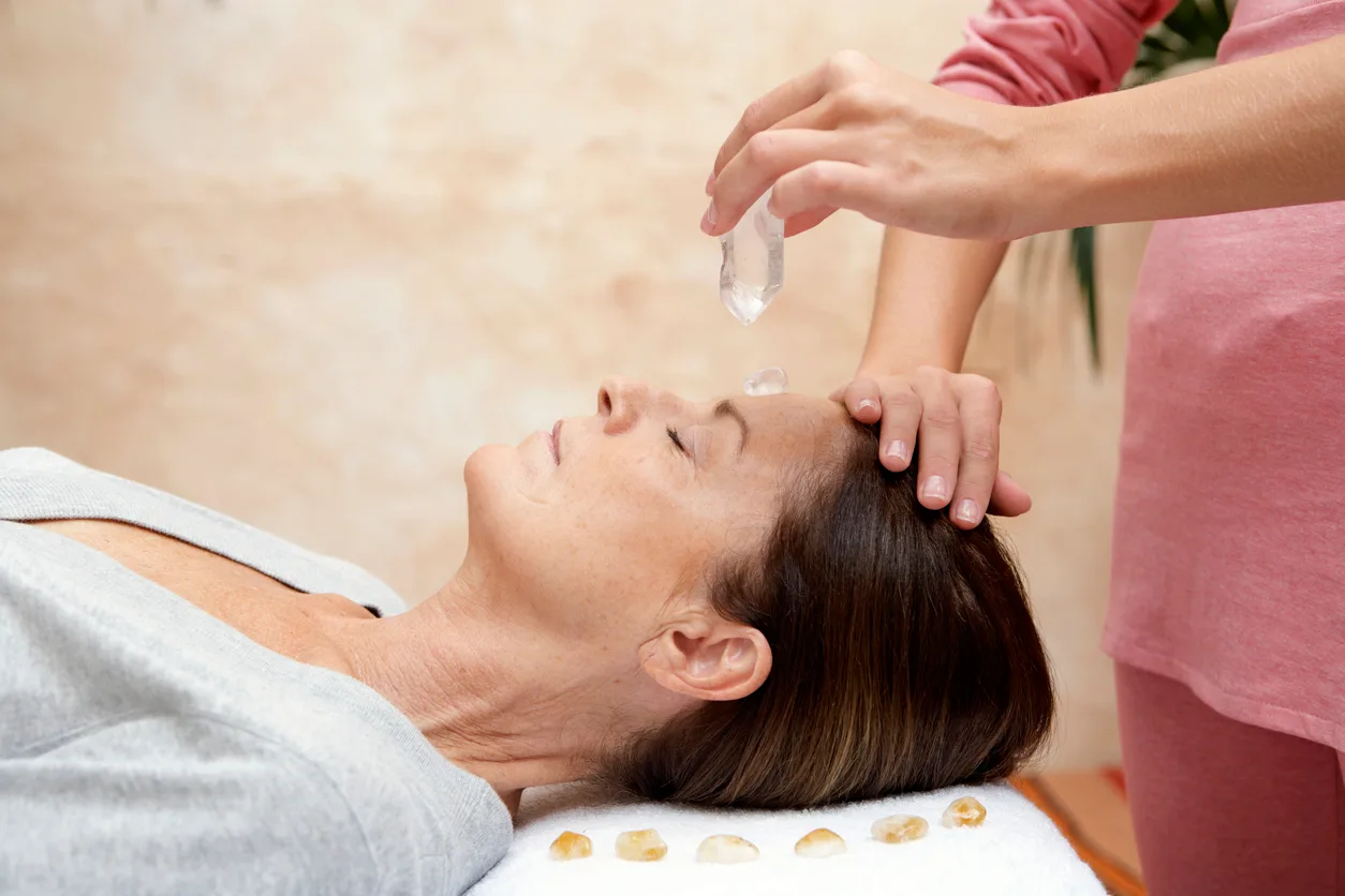 A crystal healing session with clear quartz and healing stones placed along the body